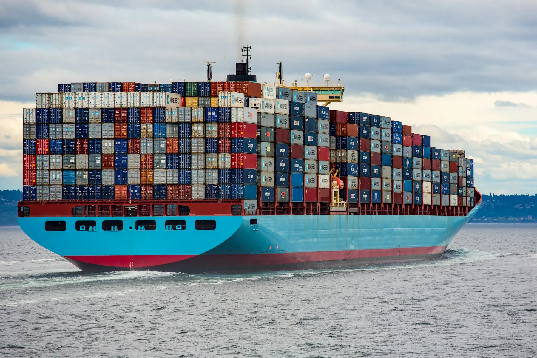 Container vessel underway with multicoloured containers stacked on deck