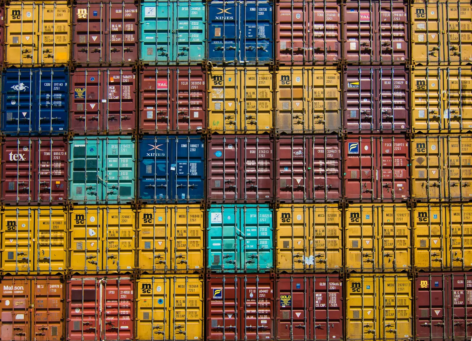 Rows of stacked shipping containers at a container yard